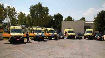 EKAV crew members stand in front of ambulances parked in a row